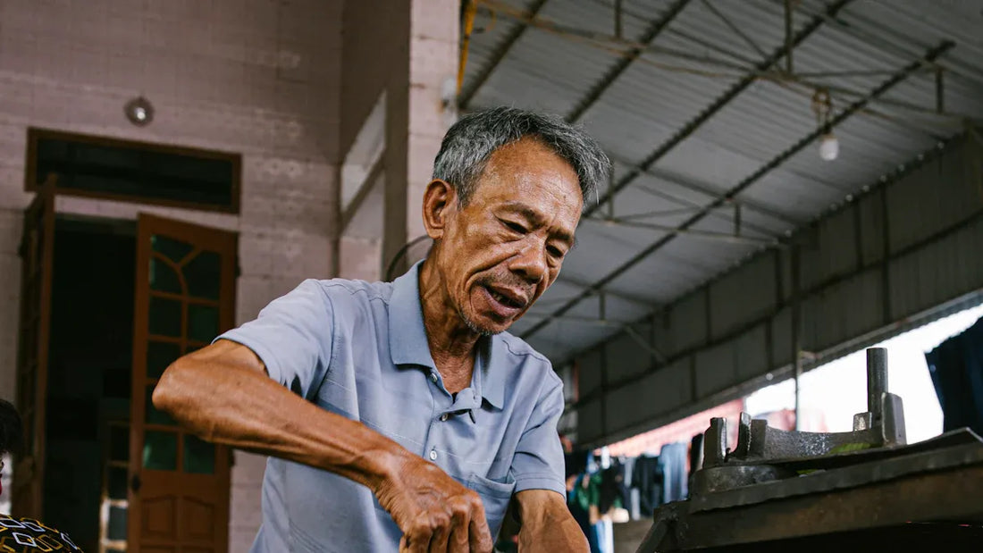 Elderly man cleaning bike chain with tools indoors focusing on bike chain cleaning maintenance